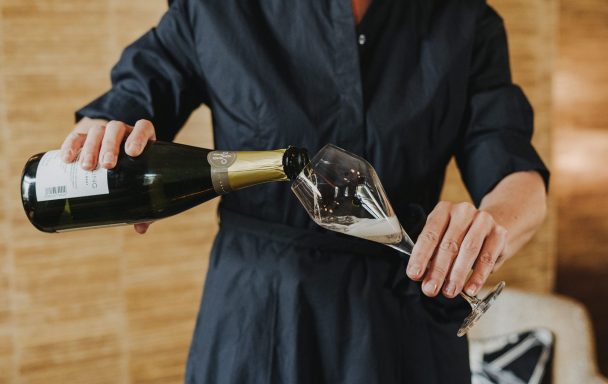 Nicole Wolbers schenkt Sekt in ein Glas.