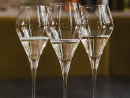 Prickelnder Sekt im Glas Drei elegante Sektgläser mit sprudelndem Getränk auf einem Tisch.